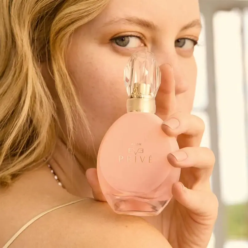 Avon Eve Prive Eau de Parfum – 50ml Shopwice a model holding avon eve prive perfume bottle on shoulder