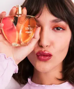 a model posing with avon love u connected perfume bottle